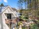 Back of house with deck and balcony overlooking wooded backyard and small patio at 4098 Kiser Cove Ln, Terrell, NC 28682
