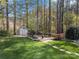 Backyard retreat featuring a charming shed, stone pathway, and fire pit area for outdoor enjoyment at 4098 Kiser Cove Ln, Terrell, NC 28682