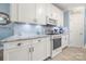 Bright kitchen with stainless steel appliances, granite countertops, and white cabinets at 4098 Kiser Cove Ln, Terrell, NC 28682