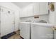 Functional laundry room features white cabinets, updated appliances, and door to the exterior at 4098 Kiser Cove Ln, Terrell, NC 28682