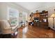 Elegant home office featuring built-in wooden shelves, a desk, and a cozy sitting area by the window at 4098 Kiser Cove Ln, Terrell, NC 28682