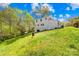 The charming two-story home features a lovely yard, set against a backdrop of lush greenery and a bright blue sky at 4375 Creek Ave, Midland, NC 28107