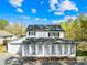 Classic two-story home featuring white siding, black shutters, and a bright sunroom addition at 4375 Creek Ave, Midland, NC 28107