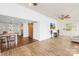Stylish living area with wood floors transitioning to an open kitchen featuring white cabinets and modern lighting at 4375 Creek Ave, Midland, NC 28107
