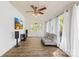Bright sunroom with hardwood floors, white paneled walls, and large windows with white curtains at 4375 Creek Ave, Midland, NC 28107