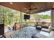 Covered back porch featuring outdoor seating, ceiling fan, and wooded backyard views at 4511 Morning Dove Ct, Denver, NC 28037
