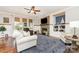 Inviting living room features a cozy fireplace, TV, ceiling fan, and comfortable seating with a blue patterned area rug at 4511 Morning Dove Ct, Denver, NC 28037