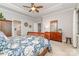 Bright main bedroom featuring a tray ceiling, ceiling fan, wooden furniture, and ensuite bathroom at 4511 Morning Dove Ct, Denver, NC 28037