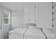 This bright laundry area includes a window, cabinet storage and a washer and dryer at 481 Union Cemetery Sw Rd, Concord, NC 28027