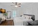 This bright bedroom features a ceiling fan, a window and decorative pillows on the plush bed at 481 Union Cemetery Sw Rd, Concord, NC 28027