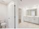 Well-lit bathroom featuring double vanity, tiled floors, and an open doorway at 5016 Poplin Vly, Cherryville, NC 28021