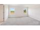 Bright bedroom featuring neutral carpeting and natural light from two windows overlooking greenery at 5016 Poplin Vly, Cherryville, NC 28021
