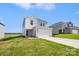 Modern two-story home with light gray siding, a large garage, and a green lawn at 5016 Poplin Vly, Cherryville, NC 28021