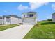 Inviting two-story home featuring light gray siding, a large garage, and a green lawn at 5016 Poplin Vly, Cherryville, NC 28021