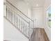 Elegant staircase with carpeted steps, white banister, and luxury vinyl plank flooring at 5016 Poplin Vly, Cherryville, NC 28021