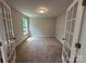 Bright carpeted room with glass panel French doors and a window at 5100 Verona Rd # 96, Charlotte, NC 28213