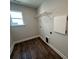Bright laundry room with wood floors, a window, and shelving for storage solutions at 5100 Verona Rd # 96, Charlotte, NC 28213