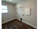 Bright laundry room with wood floors, a window, and shelving for storage solutions at 5100 Verona Rd # 96, Charlotte, NC 28213