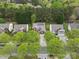A drone view shows the house and neighborhood with lush green trees in a natural setting at 512 Red Oak Ct, Tega Cay, SC 29708