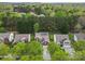 A drone view shows the house and neighborhood with lush green trees in a natural setting at 512 Red Oak Ct, Tega Cay, SC 29708