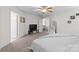 Cozy bedroom features neutral walls, carpet, ceiling fan, tv and openings to other areas of the house at 512 Red Oak Ct, Tega Cay, SC 29708