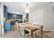 Modern eat-in kitchen with granite countertops, stainless steel appliances, and a wooden table for six at 512 Red Oak Ct, Tega Cay, SC 29708