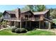 Back of house featuring a large deck, stone chimney, and outdoor seating areas, perfect for entertaining at 7424 Windy Pine Cir, Denver, NC 28037