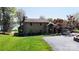 Stone-clad home with lush green lawn and mature trees; features a side-entry garage at 7424 Windy Pine Cir, Denver, NC 28037