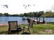 Relaxing view of the lake with a boat dock, chairs on the lawn, and peaceful waterfront living at 7424 Windy Pine Cir, Denver, NC 28037