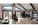Inviting living room with high ceilings, exposed beams, a stone fireplace and access to the deck at 7424 Windy Pine Cir, Denver, NC 28037