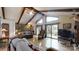 Spacious living room featuring exposed beams, hardwood floors, and multiple points of access to the outdoor deck at 7424 Windy Pine Cir, Denver, NC 28037