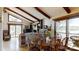 Open concept living room with high ceilings, exposed beams, a stone fireplace, and access to the deck at 7424 Windy Pine Cir, Denver, NC 28037