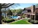 A beautiful backyard pool, with lush landscaping and a multi-level stone and wood home at 7424 Windy Pine Cir, Denver, NC 28037