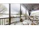 Relaxing screened-in porch overlooking the lake with comfortable wicker furniture and ceiling fan at 7424 Windy Pine Cir, Denver, NC 28037