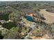 Stunning aerial view of property with a private lake and surrounding lush greenery and multiple outbuildings at 7545 Brancy St, Kannapolis, NC 28081