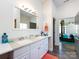Bright bathroom with double sinks, white cabinets, and a view of the Primary bedroom, plus modern lighting fixtures at 7545 Brancy St, Kannapolis, NC 28081