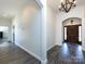 Inviting home entryway with elegant chandelier, hardwood floors, and a wooden door with sidelights and religious symbol at 7545 Brancy St, Kannapolis, NC 28081