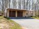 Exterior of an outbuilding featuring three large garage doors beneath a metal awning, and a paved driveway at 7545 Brancy St, Kannapolis, NC 28081