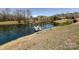 Scenic pond view with a boat, surrounded by lush trees, enhancing the property's natural beauty at 7545 Brancy St, Kannapolis, NC 28081
