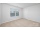 Bright, carpeted bedroom featuring a large window and neutral walls at 7730 Woolsey Dr, Gastonia, NC 28056