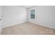A cozy room with neutral carpet, window, and base trim, ready for personalization at 7730 Woolsey Dr, Gastonia, NC 28056