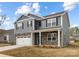 Charming two-story home with gray siding, stone accents, covered porch and two car garage at 7730 Woolsey Dr, Gastonia, NC 28056
