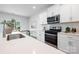 Bright kitchen boasts white cabinetry, stainless steel appliances, and a modern design for cooking and entertaining at 7730 Woolsey Dr, Gastonia, NC 28056