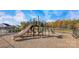 A community playground featuring slides and climbing structures, with autumn foliage and homes nearby at 7730 Woolsey Dr, Gastonia, NC 28056