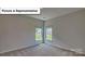 Well-lit bedroom featuring neutral walls, carpet, and two windows offering abundant natural light at 8067 Kennesaw Dr, Gastonia, NC 28056