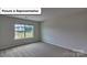 Bedroom featuring neutral walls, carpet, and a large window offering abundant natural light at 8067 Kennesaw Dr, Gastonia, NC 28056