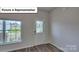 Bright entryway with wood-look flooring, a decorative glass door, and large window at 8067 Kennesaw Dr, Gastonia, NC 28056