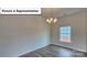 Living room with chandelier, laminate wood flooring and a large window at 8067 Kennesaw Dr, Gastonia, NC 28056