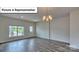 Living room with natural light, wood laminate flooring and chandelier at 8067 Kennesaw Dr, Gastonia, NC 28056
