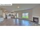 Open-concept living space with white cabinets, a fireplace, and stainless steel appliances at 8067 Kennesaw Dr, Gastonia, NC 28056